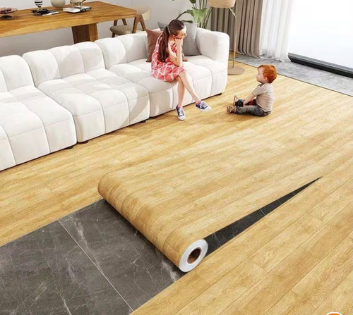 Self-adhesive wood grain decorative floor film being applied to a modern living room floor.